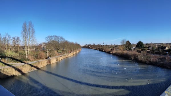 Blick von der Brücke über den Mittellandkanal am Yachthafen Hannover. Wasservögel kreisen über dem Wasser, einige schwimmen auf den Wellen.